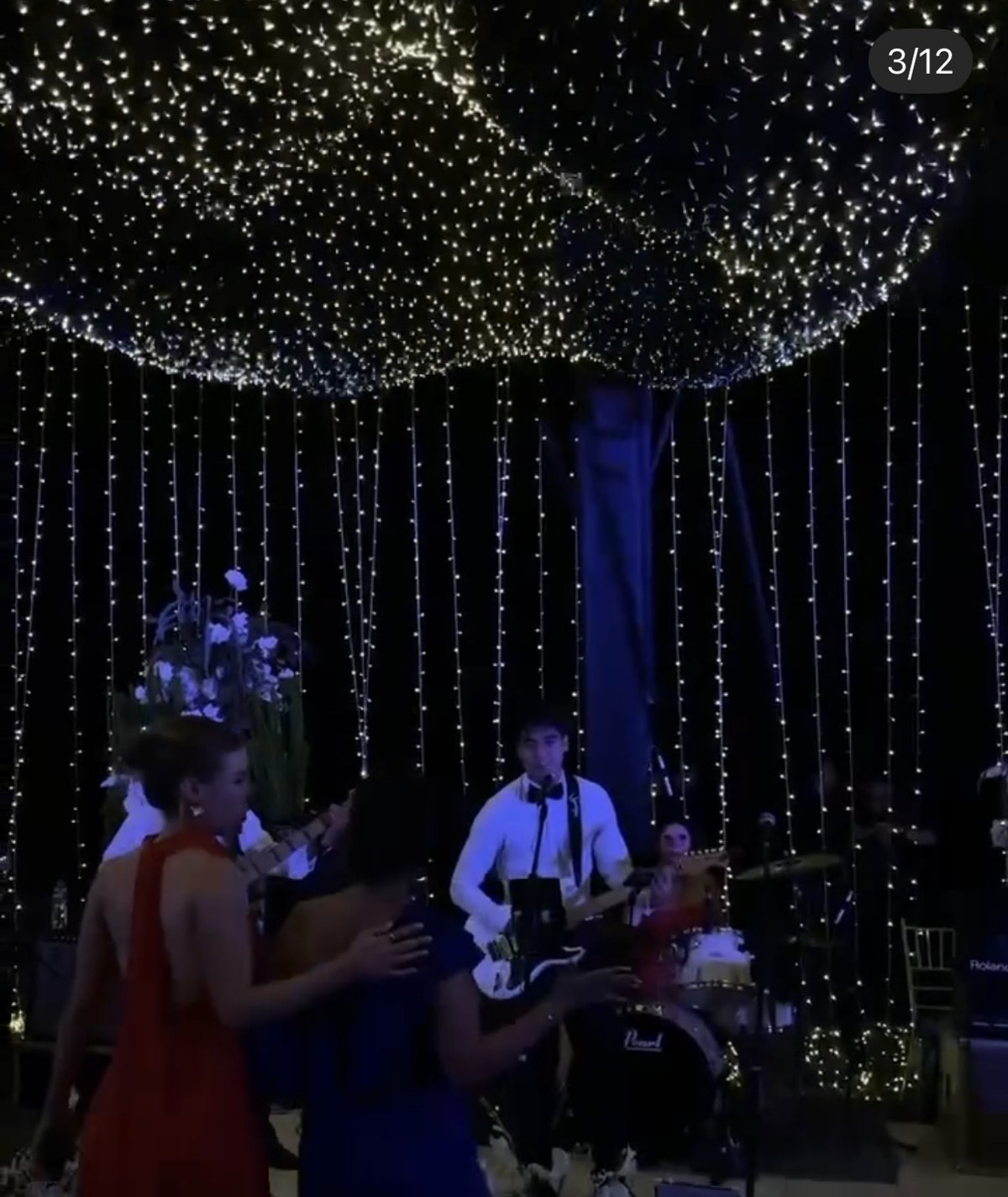 Guitar performance with a band under string lights